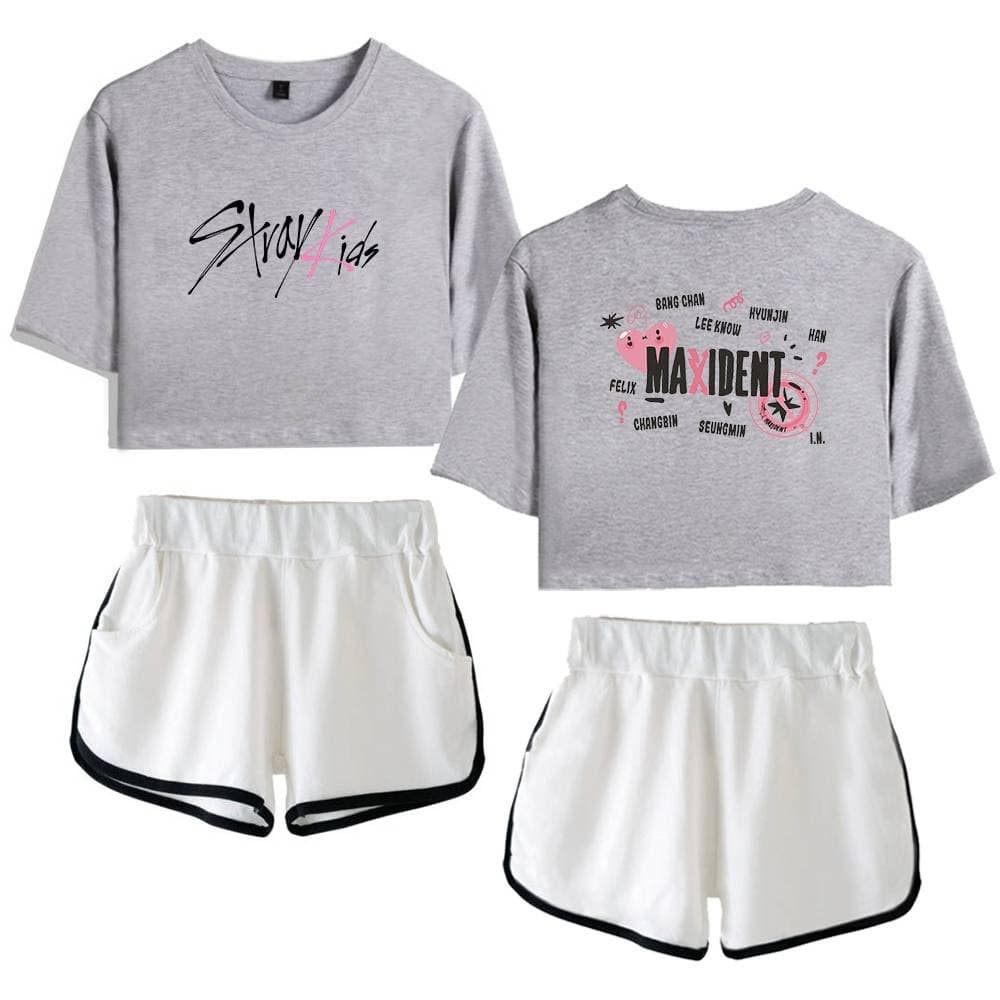 Gray cropped t-shirt with Stray Kids logo and Maxident design, paired with white sporty shorts with black trim.