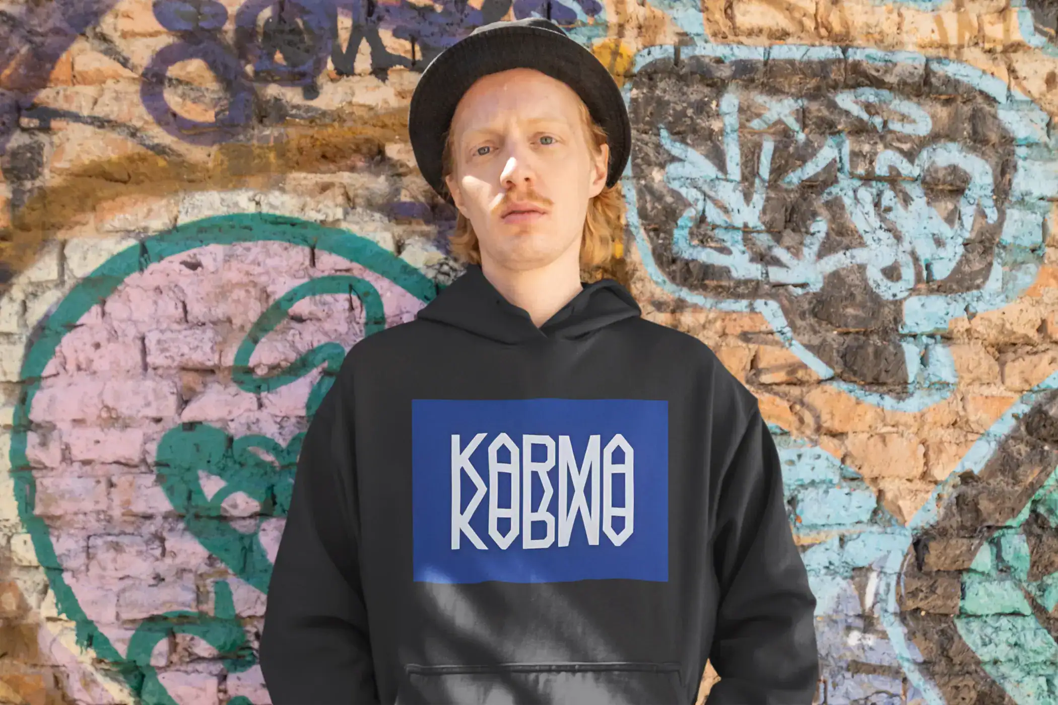 Kpop merch hoodie with bold graphic design and street art background.